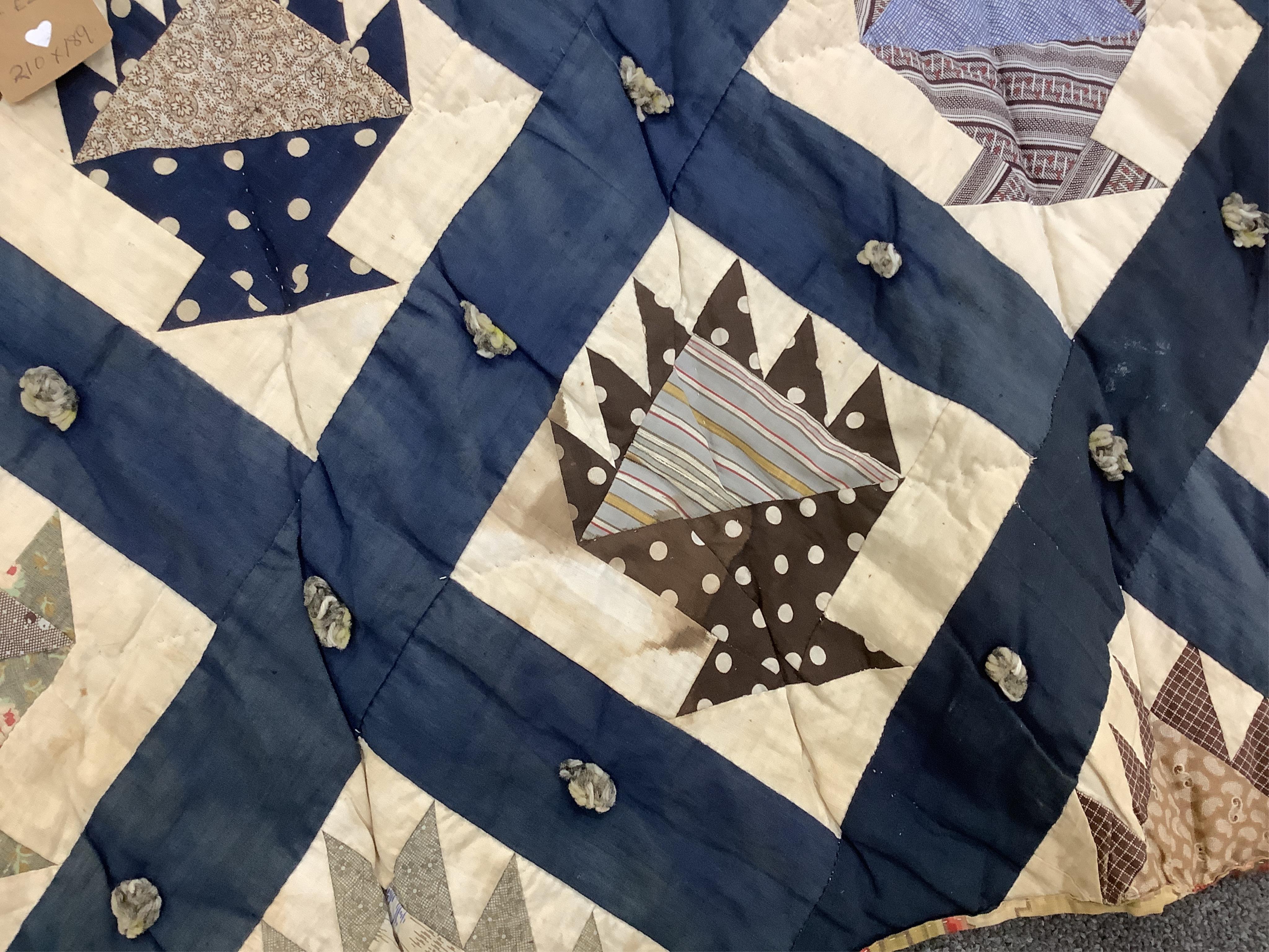 A bold handsome, American, Vermont 1865 (Civil War) ‘basket’ and lattice, hand quilted and piece tied bedcover, with an ornate floral backing. Worked with a plain navy cotton lattice border around central stylised printe